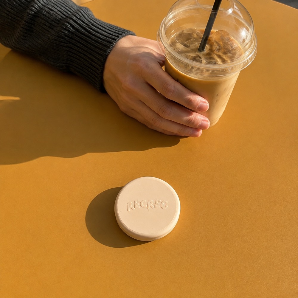 El objeto apoyado en la mesa de un café, al lado de un vaso.